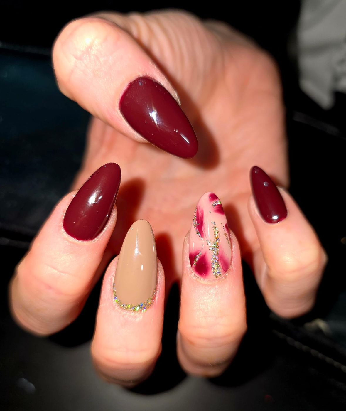 Burgundy almond nails with glitter accent